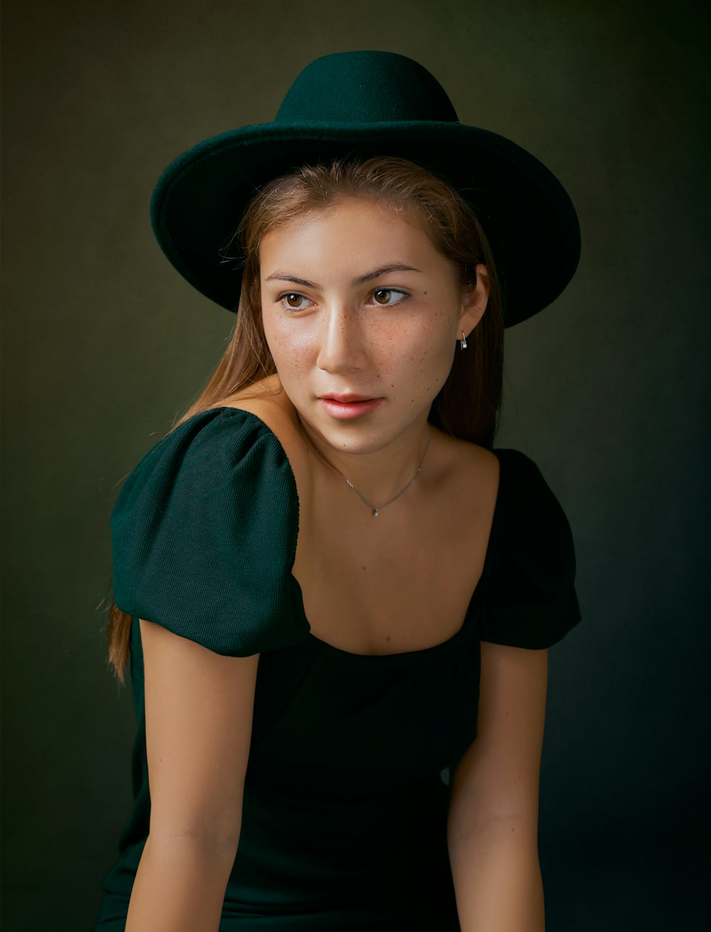 woman in black scoop neck shirt wearing blue cardigan and black hat