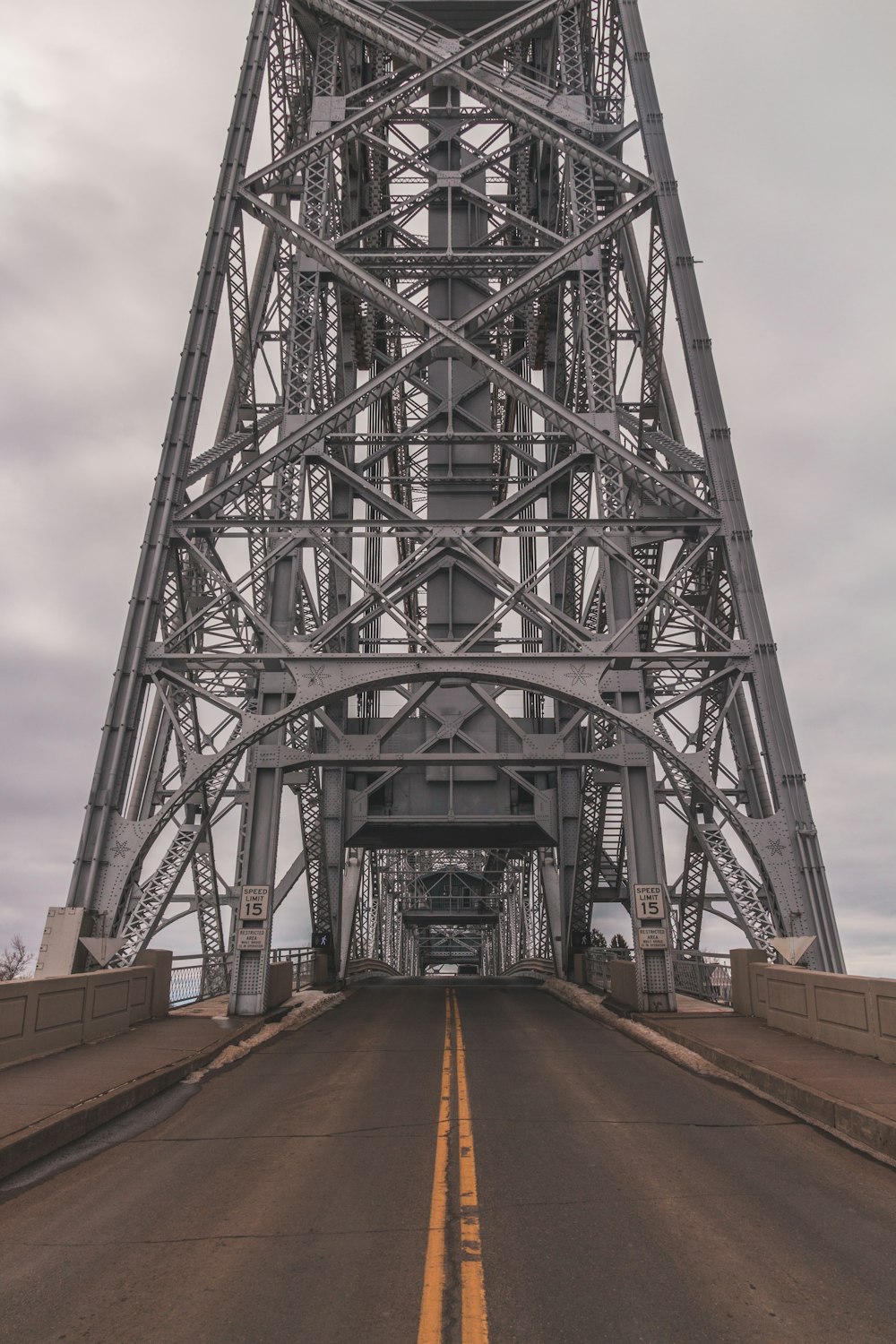 gray steel bridge under gray cloudy sky during daytime