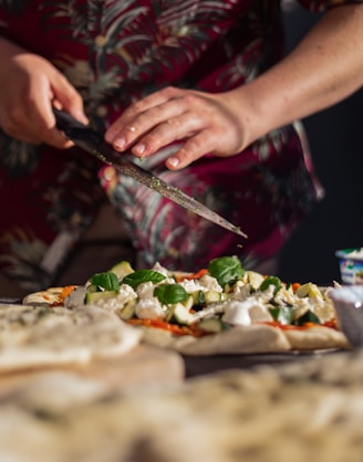 person holding knife slicing vegetable