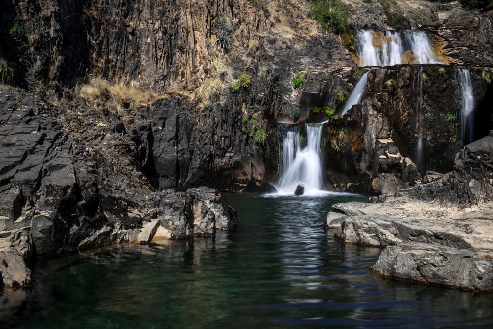 waterfalls in brown rocky mountain during daytime