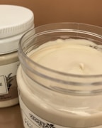 Elegant jar of moisturizer with fresh botanical ingredients around it.