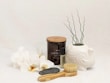 A collection of calming self-care products like candles, bath salts, and soothing oils arranged neatly.