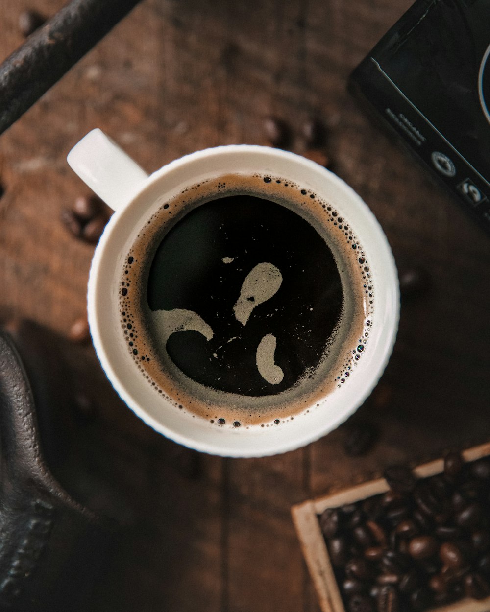 a cup of coffee sitting on top of a wooden table