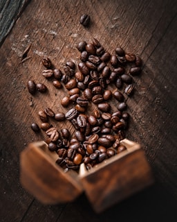 A close-up of coffee beans scattered on a rustic surface.