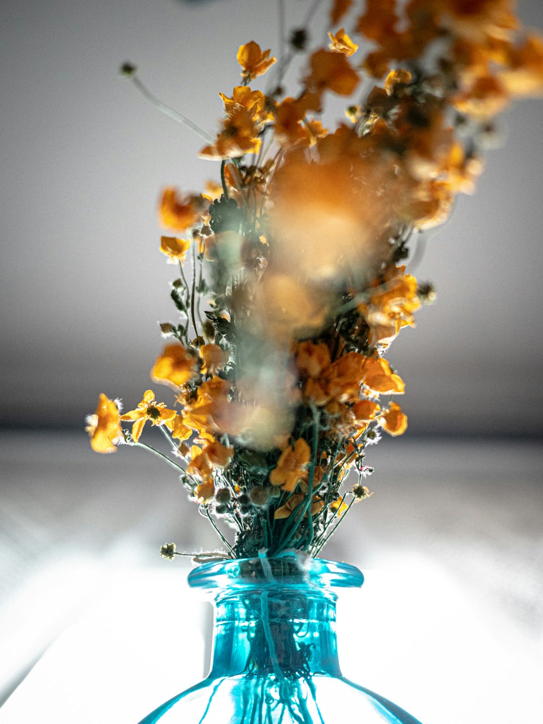 yellow flowers in blue glass vase