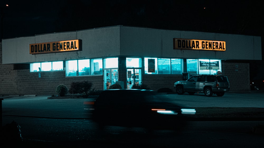 cars parked in front of store during night time