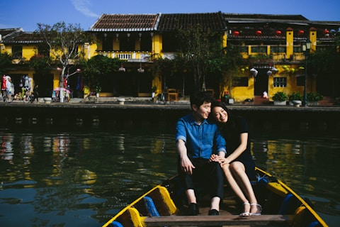 woman in blue shirt sitting on blue boat during daytime