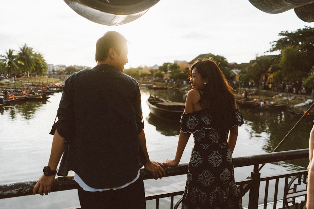 man and woman standing beside railings during daytime