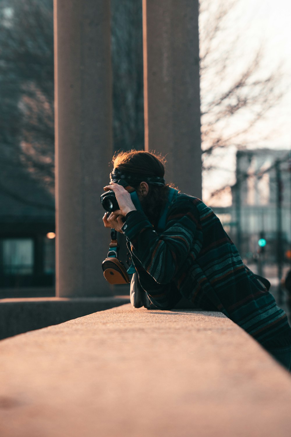 man in black and red plaid dress shirt holding black dslr camera