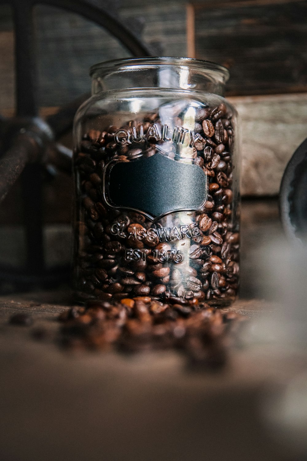 grãos de café castanhos e pretos em caneca de vidro transparente