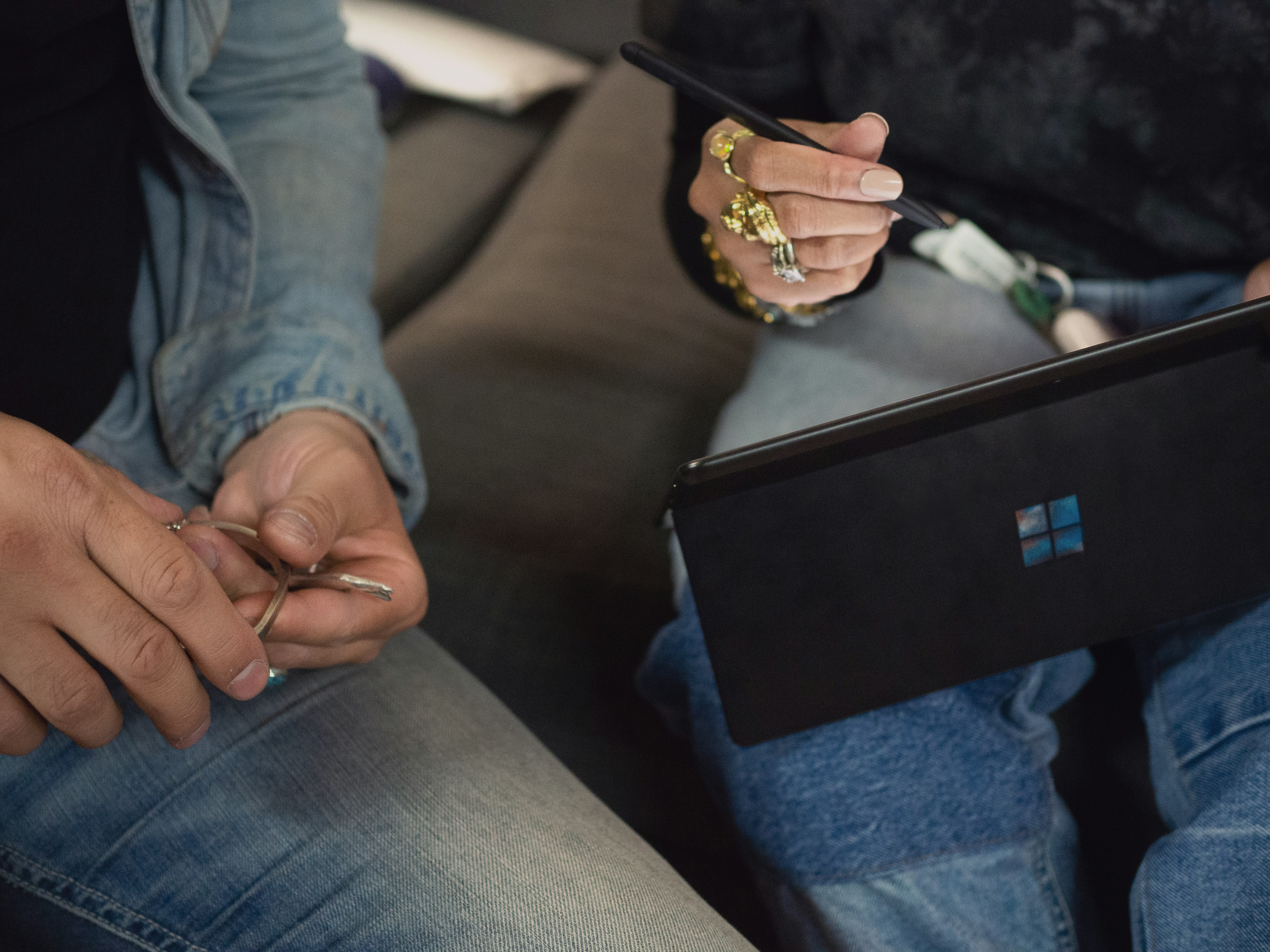 person in blue denim jeans holding Surface device