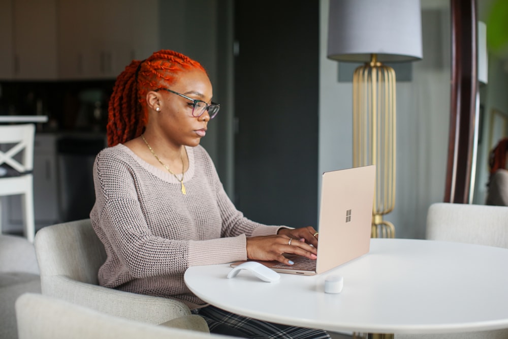 woman in gray knit sweater using Surface computer