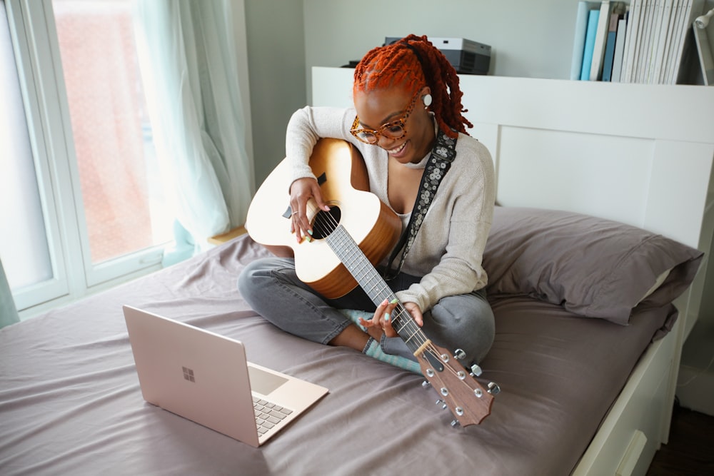 woman in white shirt playing acoustic guitar