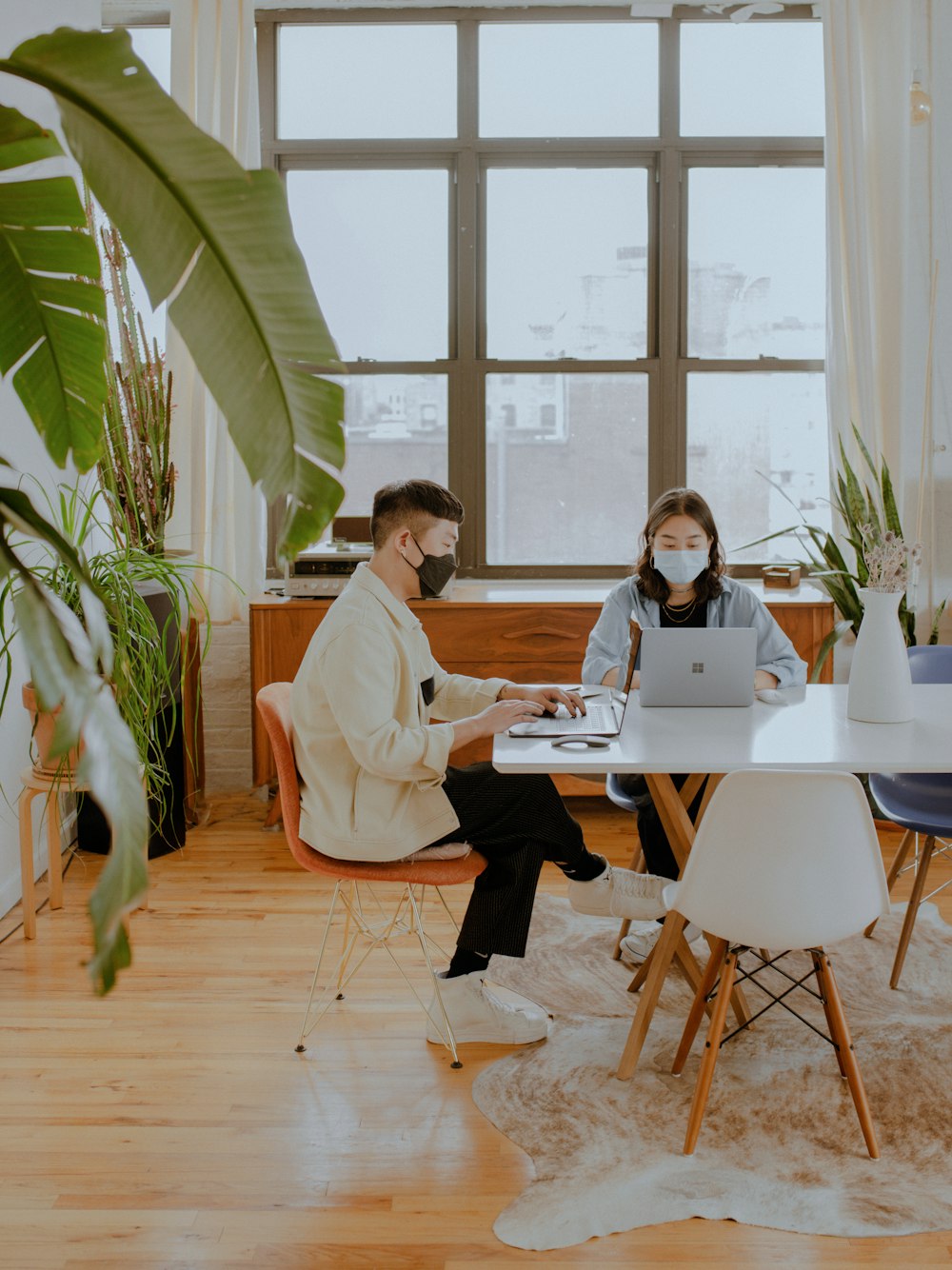 2 persone sedute al tavolo che lavorano