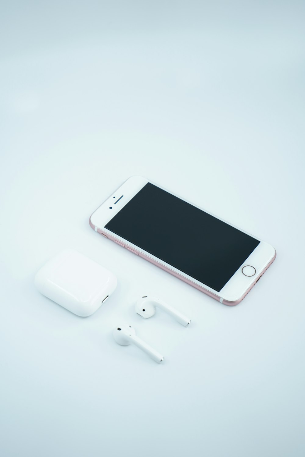 white iphone 5 c beside white earbuds