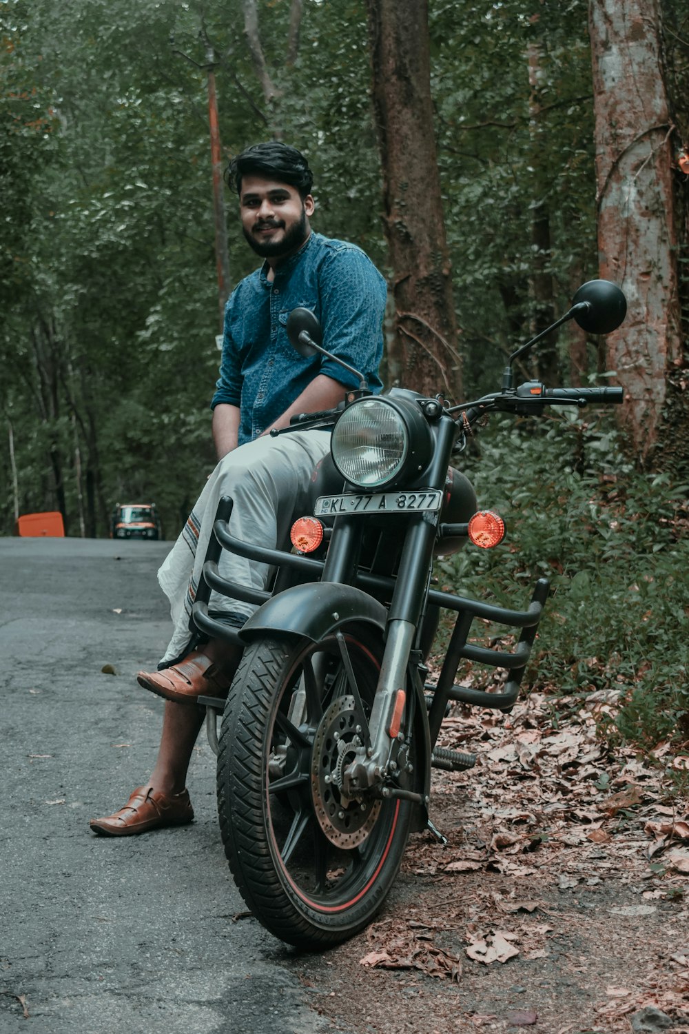 man in blue dress shirt and gray pants sitting on black motorcycle