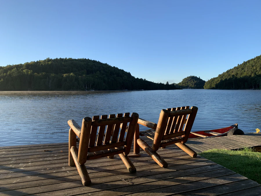 Muskoka chairs on a lakeside deck at golden hour