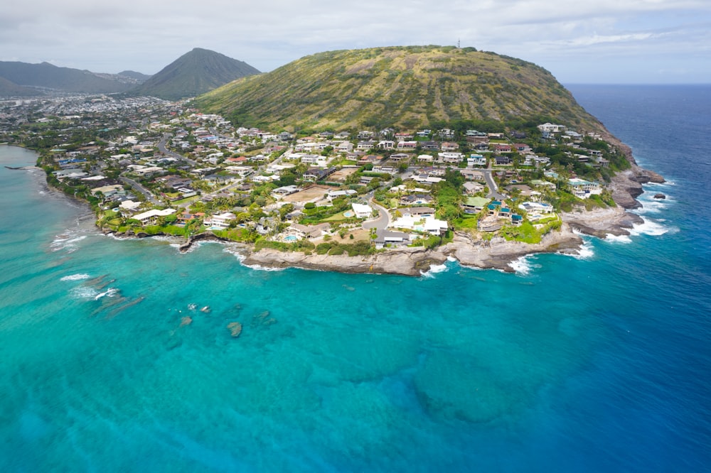 aerial view of green and brown mountain beside body of water during daytime