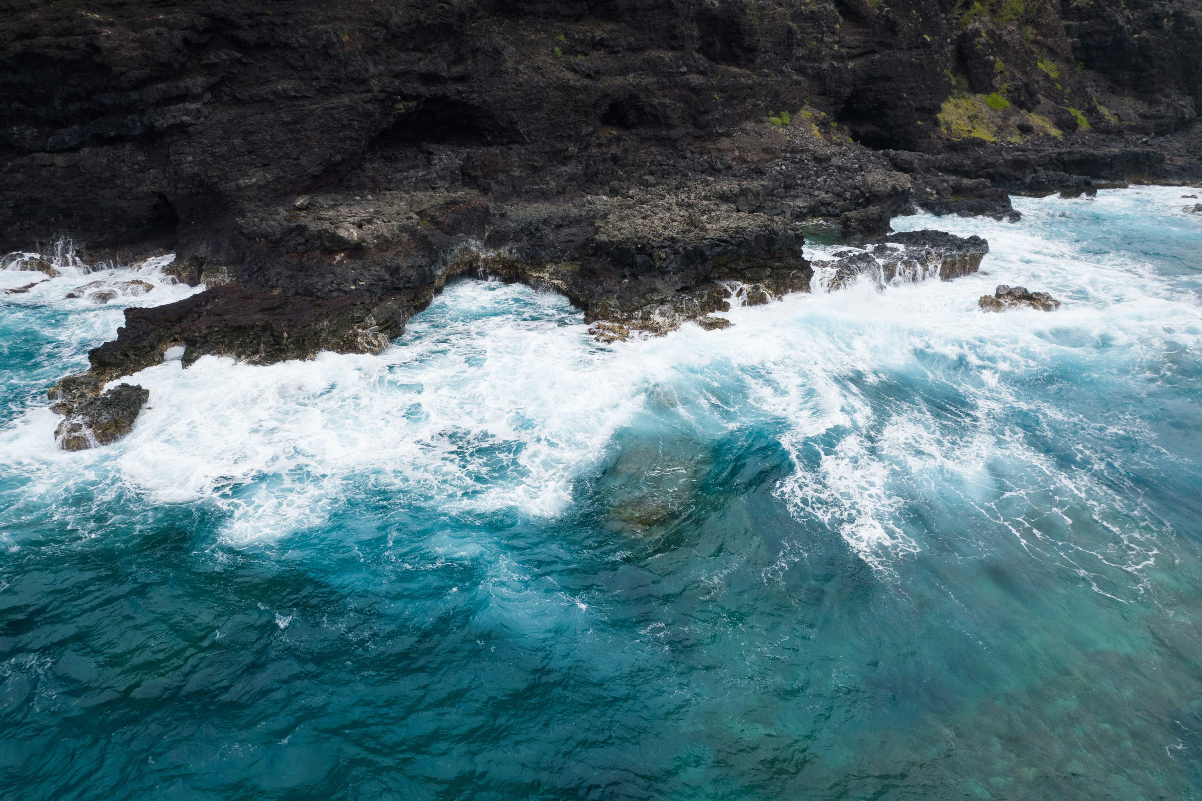 ocean waves crashing on rocky shore during daytime