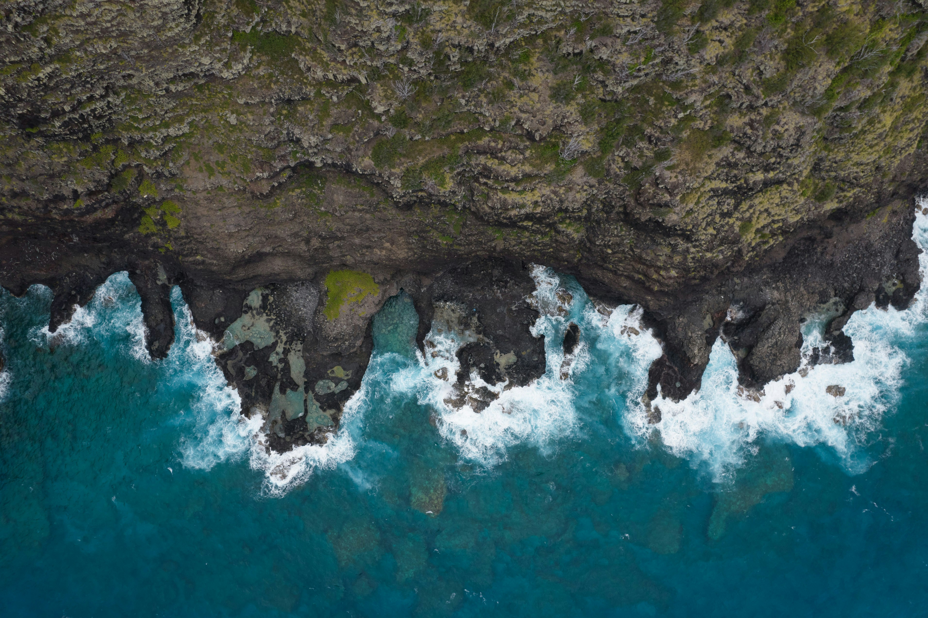brown rock formation on body of water during daytime