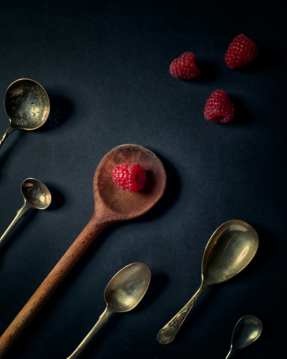 red strawberries on stainless steel spoons