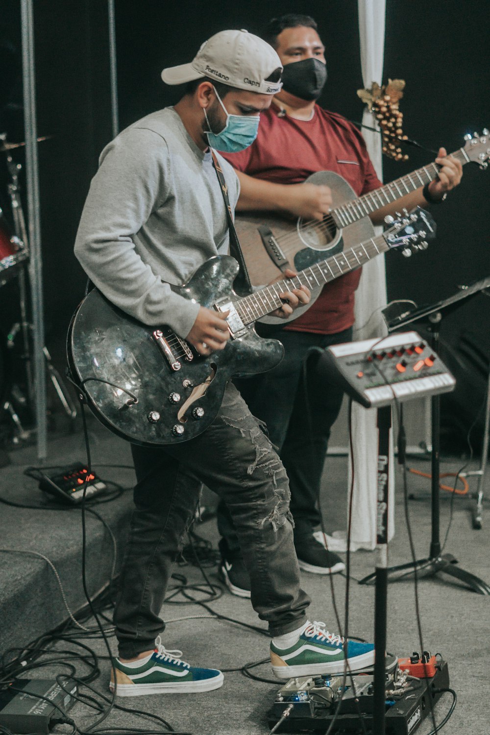 man in gray dress shirt playing electric guitar