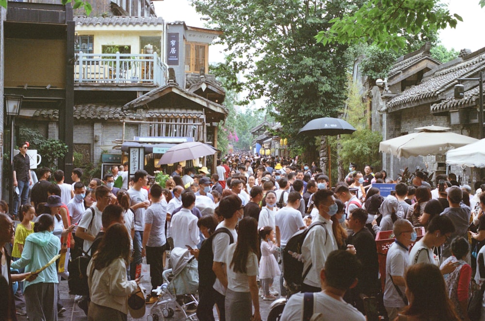 people gathering in front of brown and white concrete building during daytime