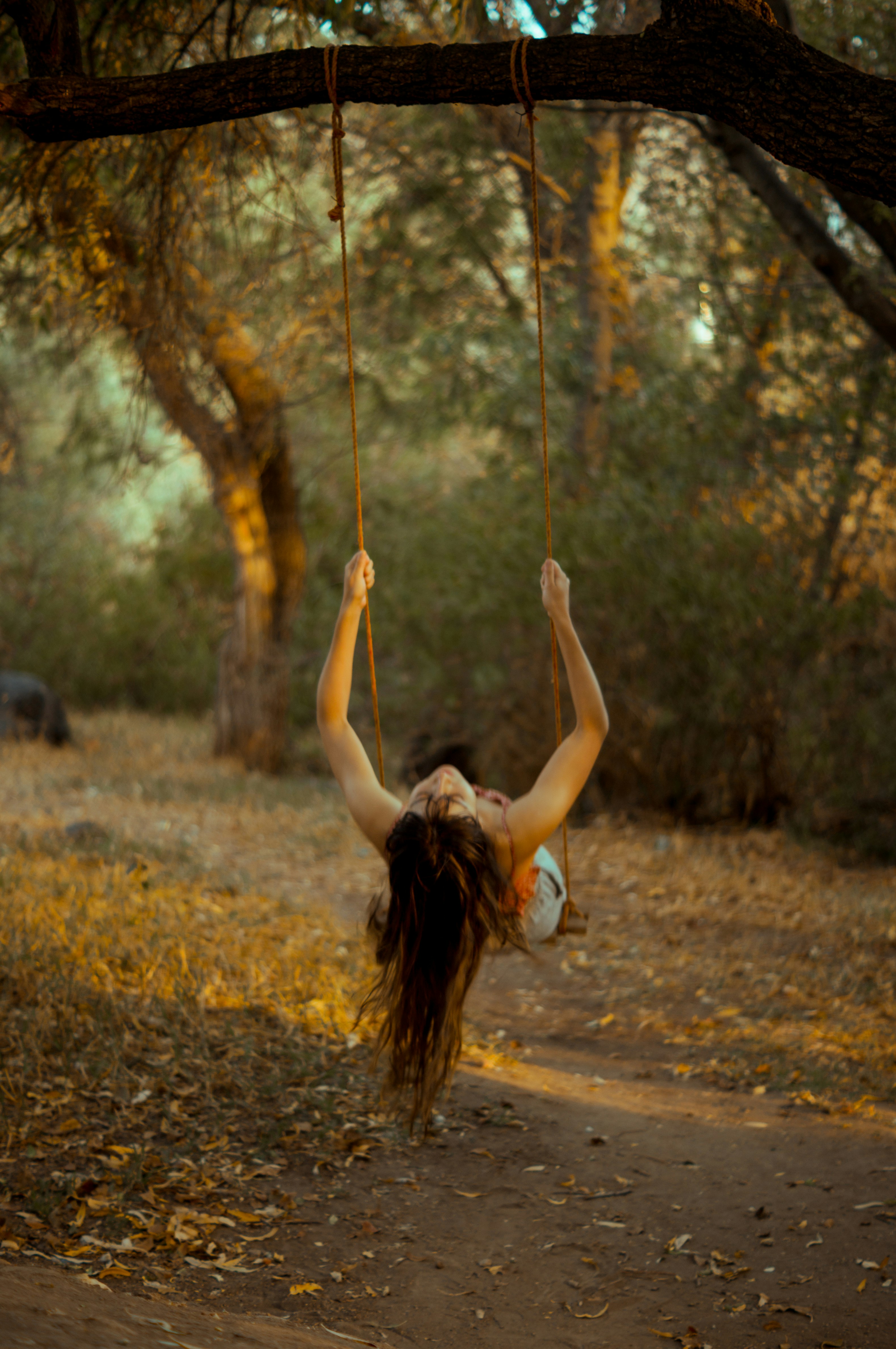 woman in black tank top sitting on swing during daytime