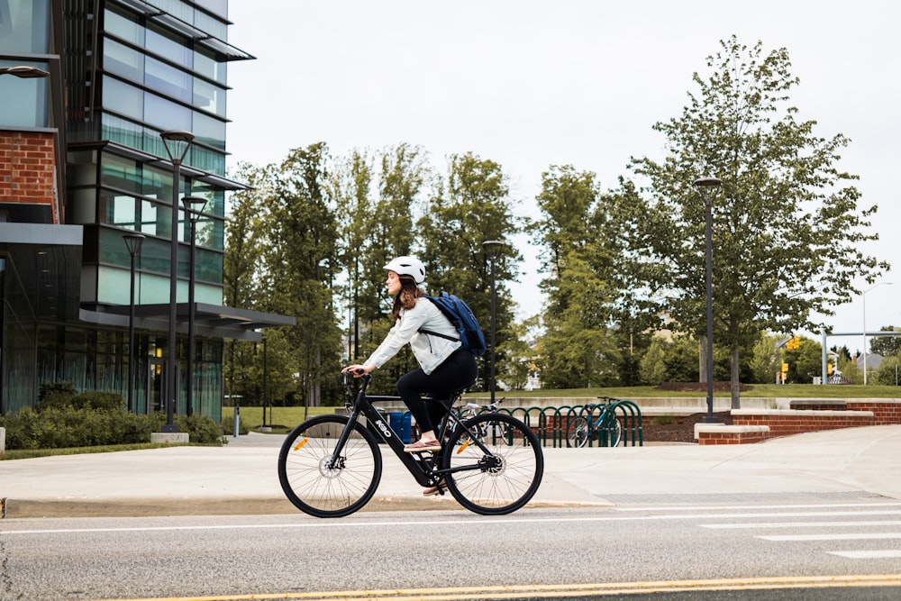 man in white shirt riding bicycle on road during daytime