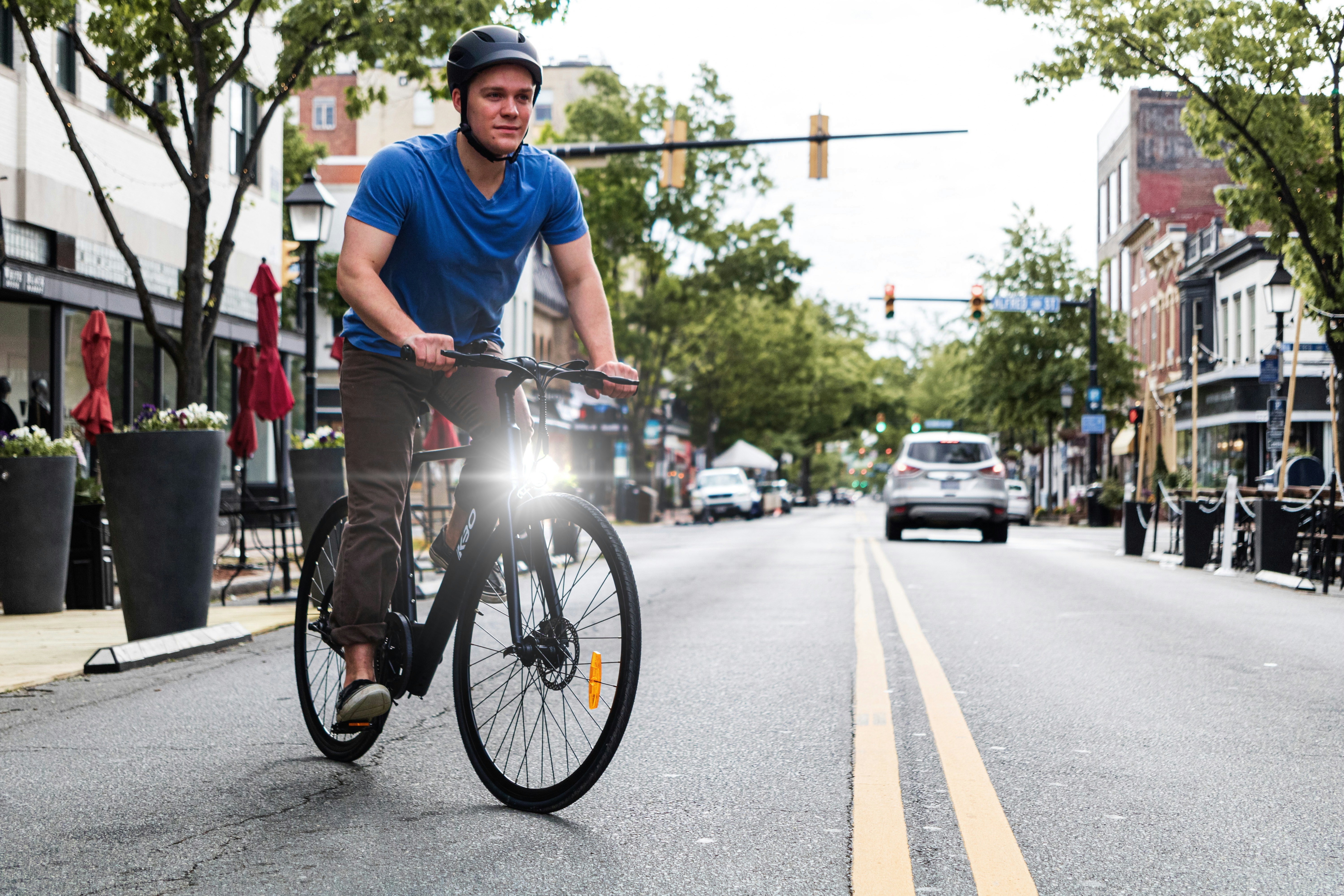 man in blue crew neck t-shirt cycling to work in a morning