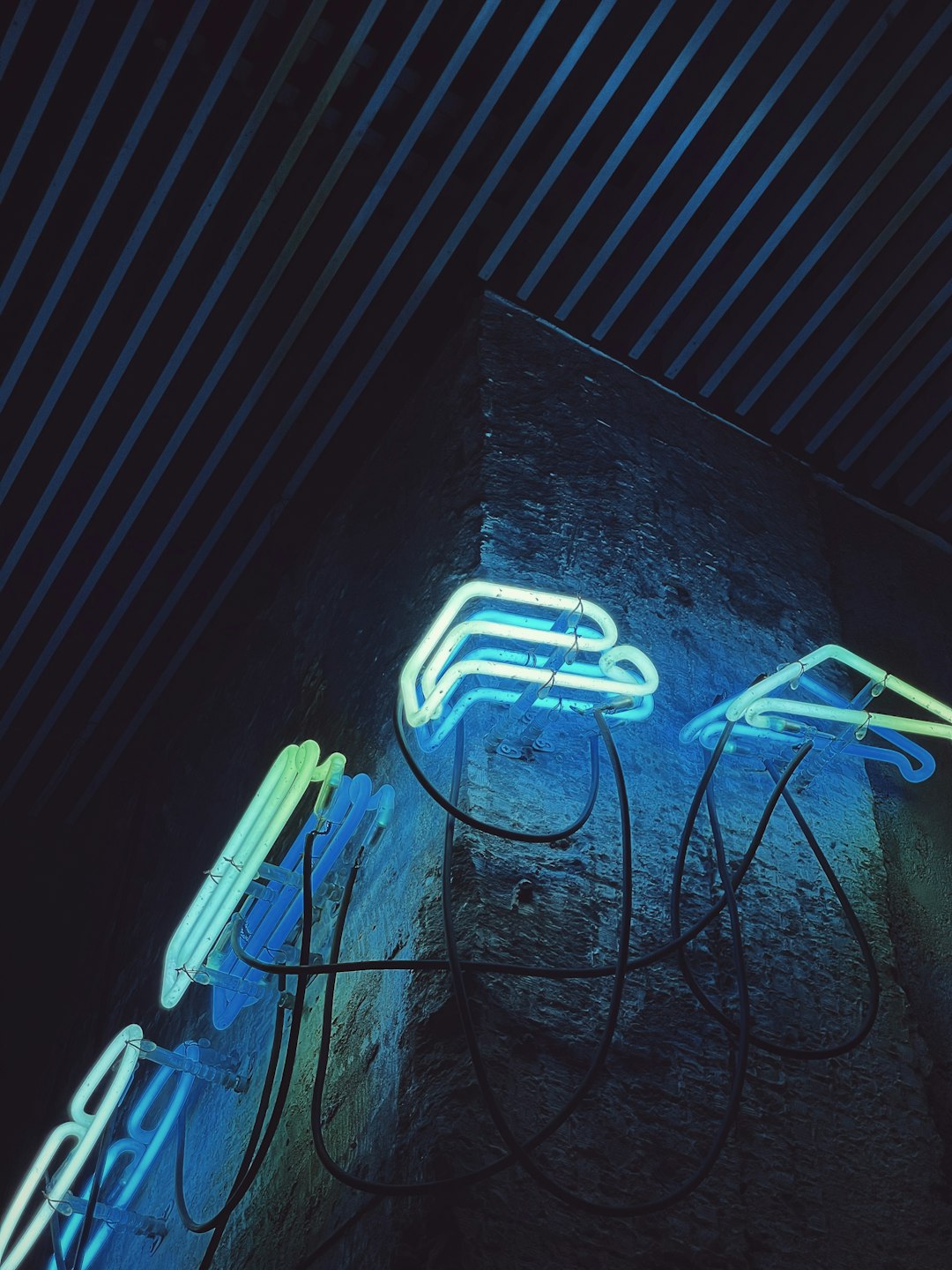 blue and white electric wires on gray concrete wall