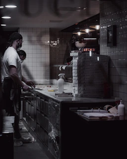A cozy kitchen scene with a couple wearing chef hats, preparing gourmet pizza together with fresh Italian ingredients.
