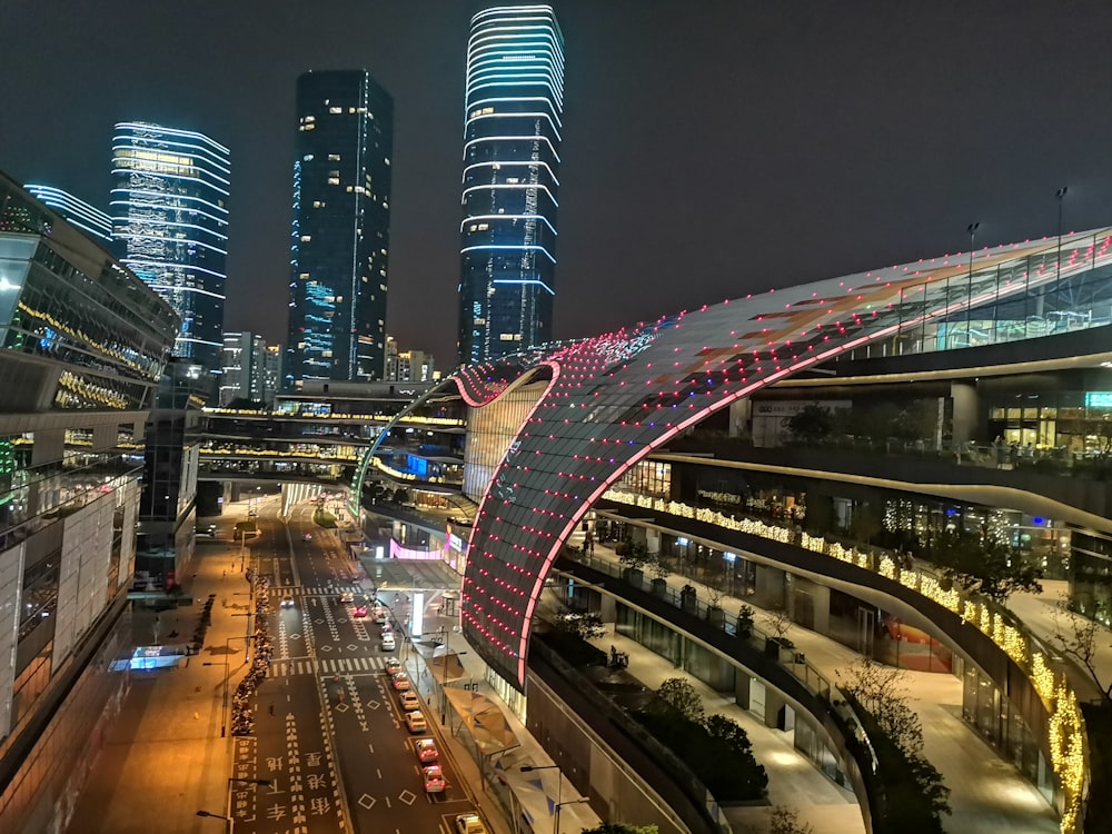 cars on road near city buildings during night time