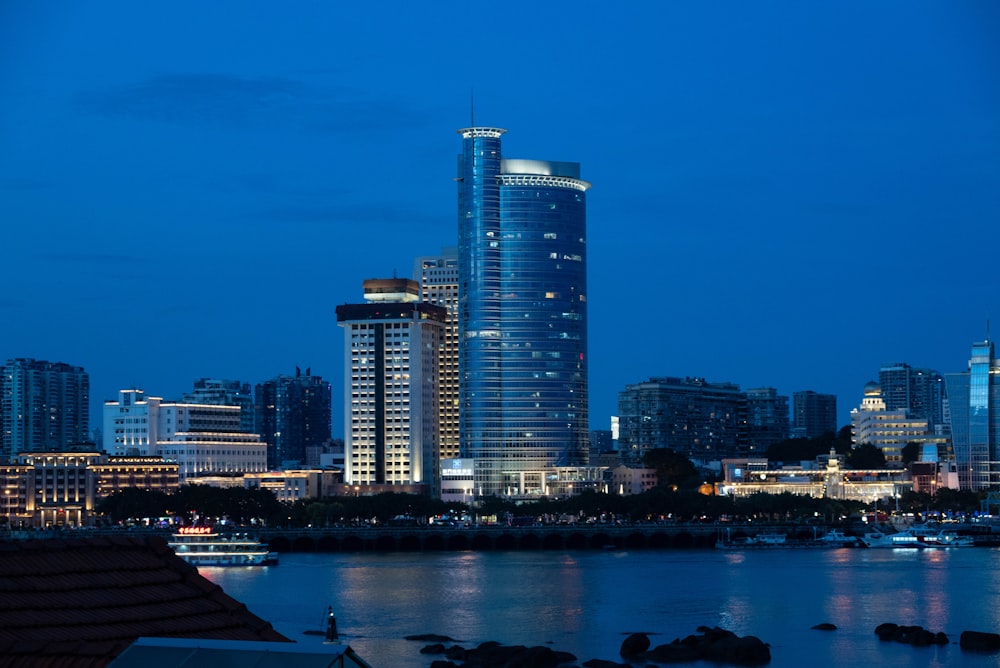 city skyline across body of water during night time