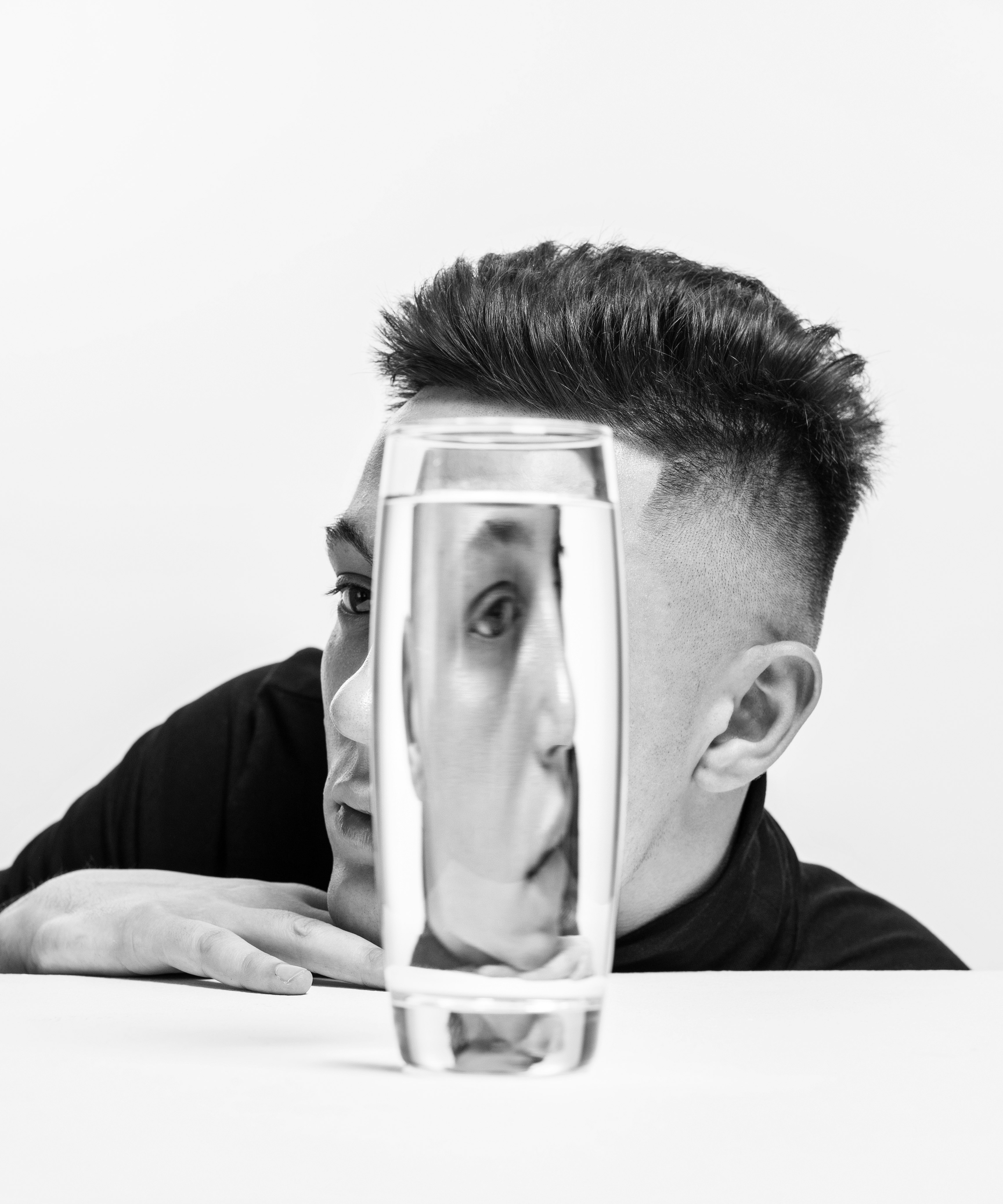 man in black shirt holding clear glass container