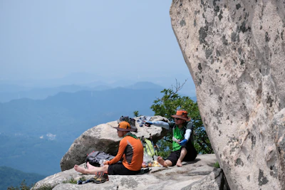 A couple sharing a private picnic on a secluded mountain plateau under clear blue skies.