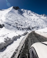 black car on road near snow covered mountain during daytime