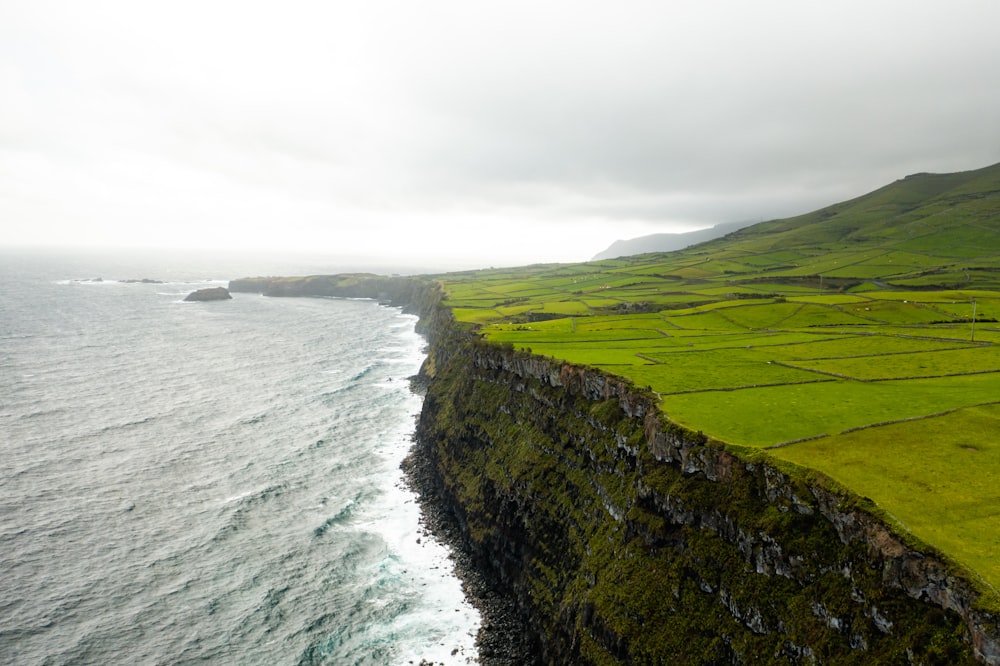 green grass field beside body of water during daytime