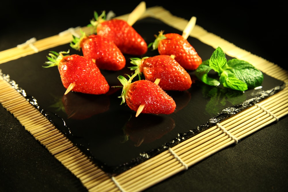 red strawberries on black ceramic plate