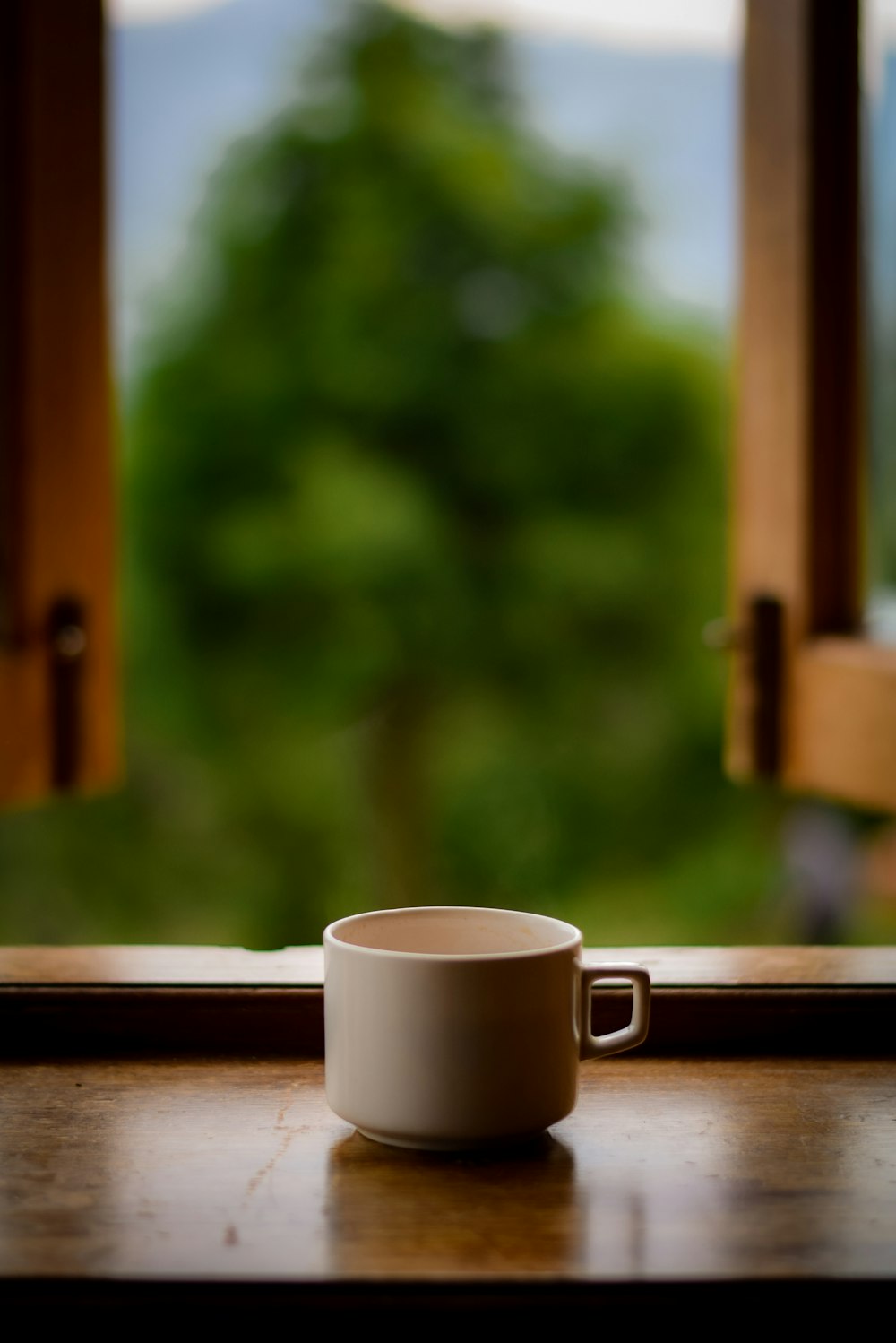 white ceramic mug on brown wooden table