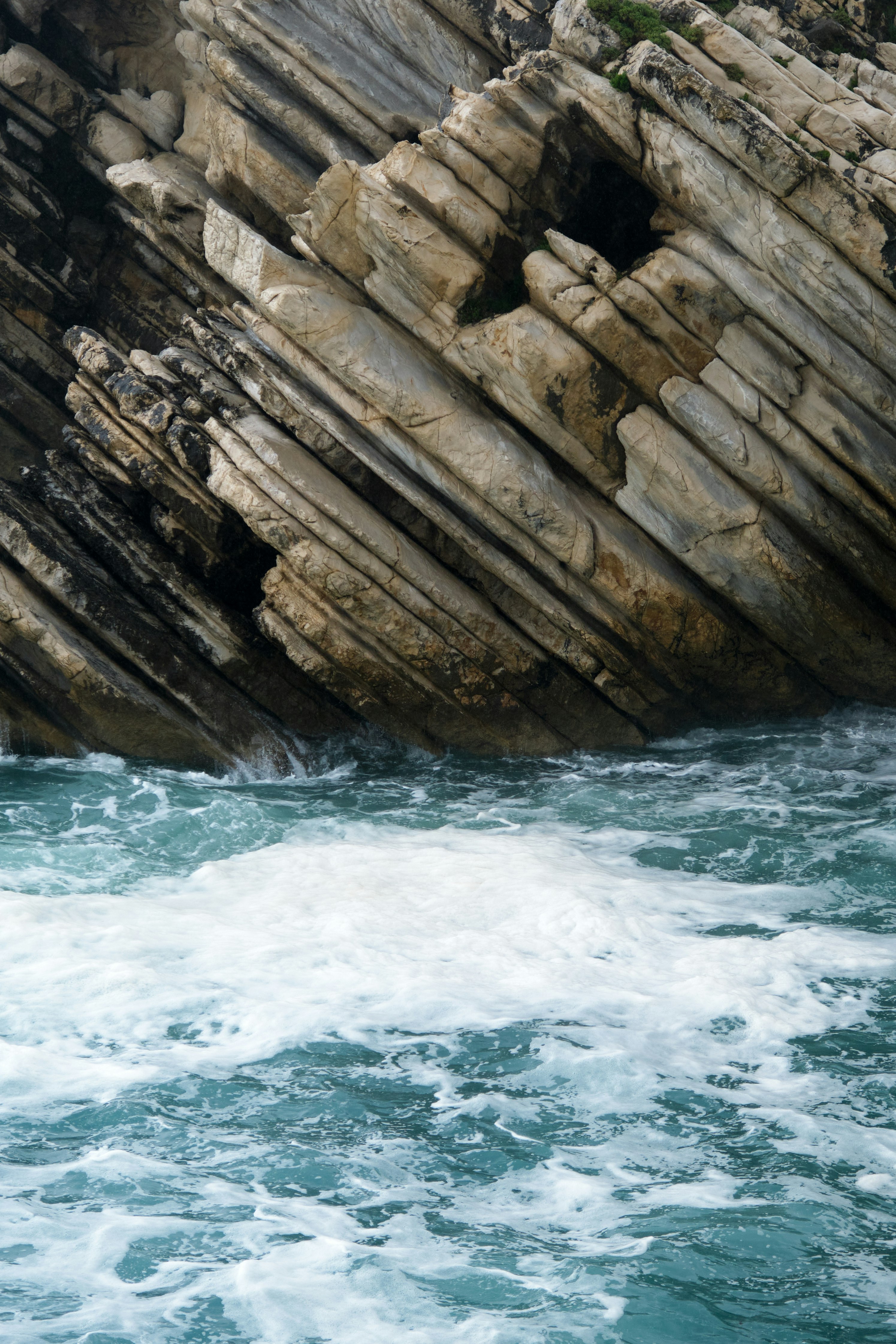 brown rock formation beside body of water during daytime