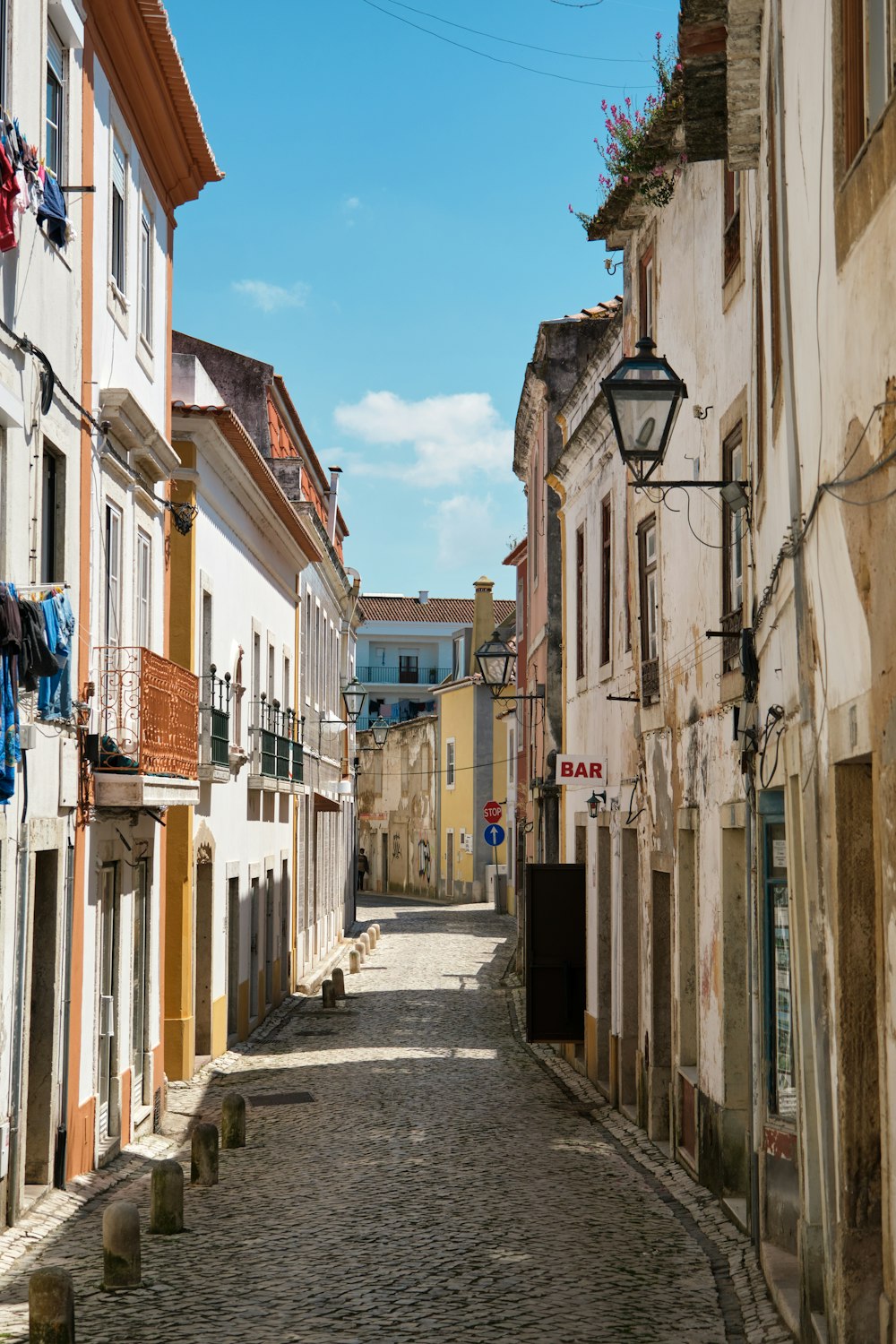 empty street between concrete buildings under blue sky during daytime