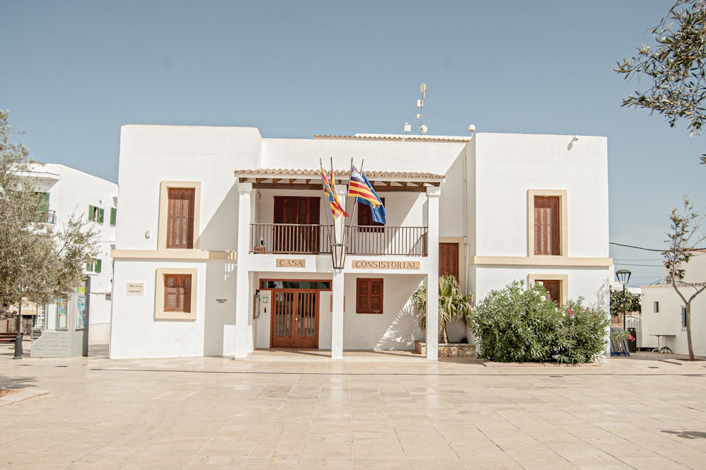 white concrete building with flags on top during daytime