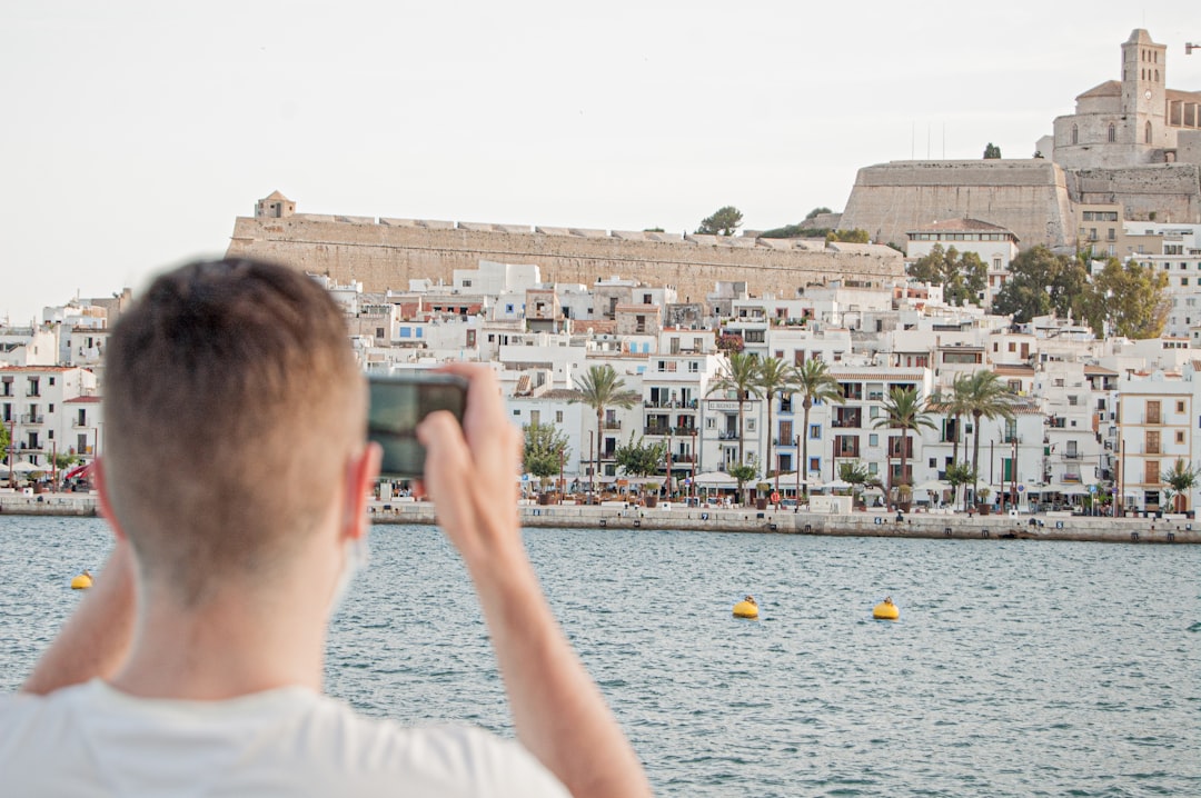 man in white shirt looking at city buildings during daytime