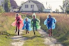 people in green and blue jacket walking on green grass field during daytime