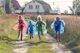 people in green and blue jacket walking on green grass field during daytime