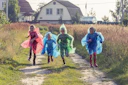 people in green and blue jacket walking on green grass field during daytime