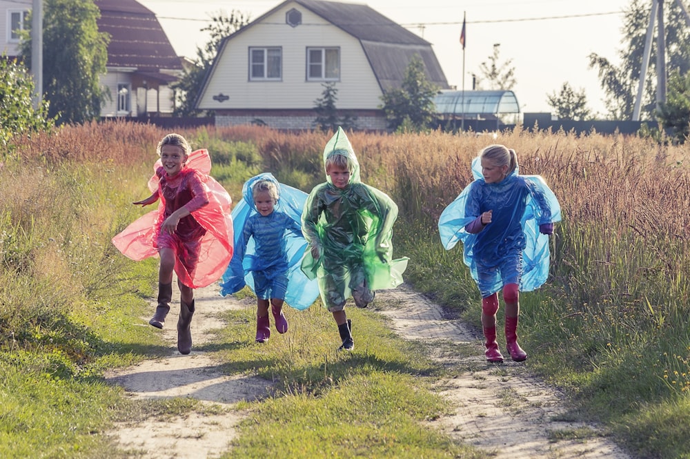 Menschen in grüner und blauer Jacke, die tagsüber auf grünem Rasen spazieren gehen