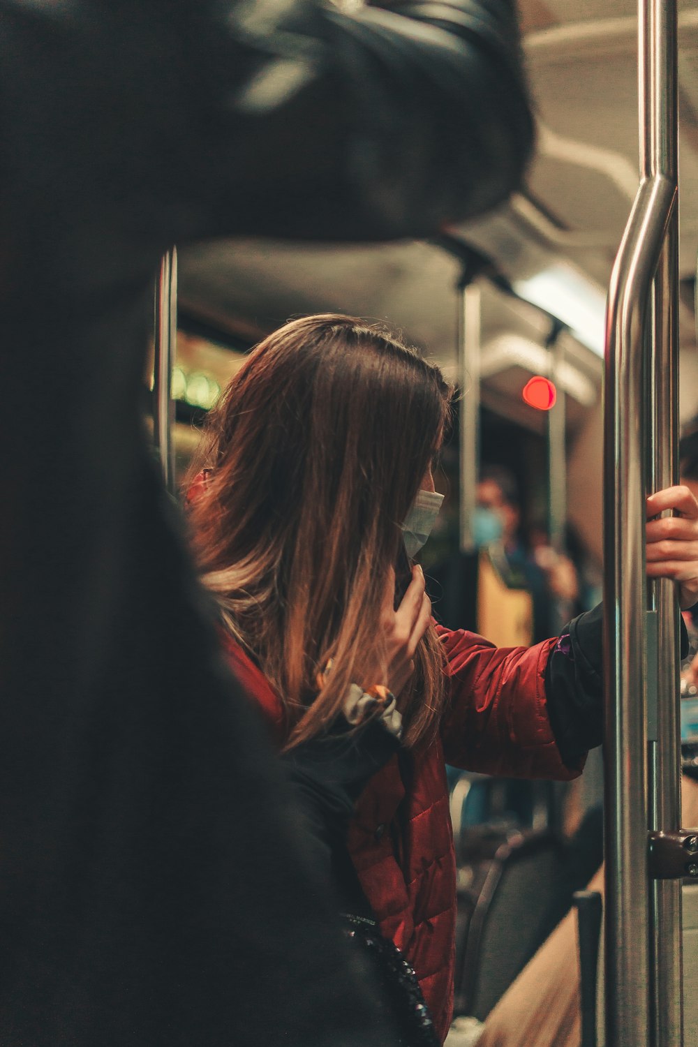 woman in red jacket sitting on train