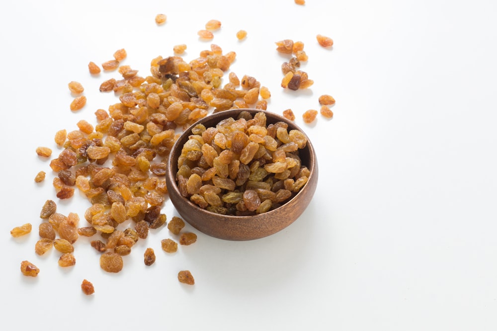 brown and white nuts on brown wooden bowl